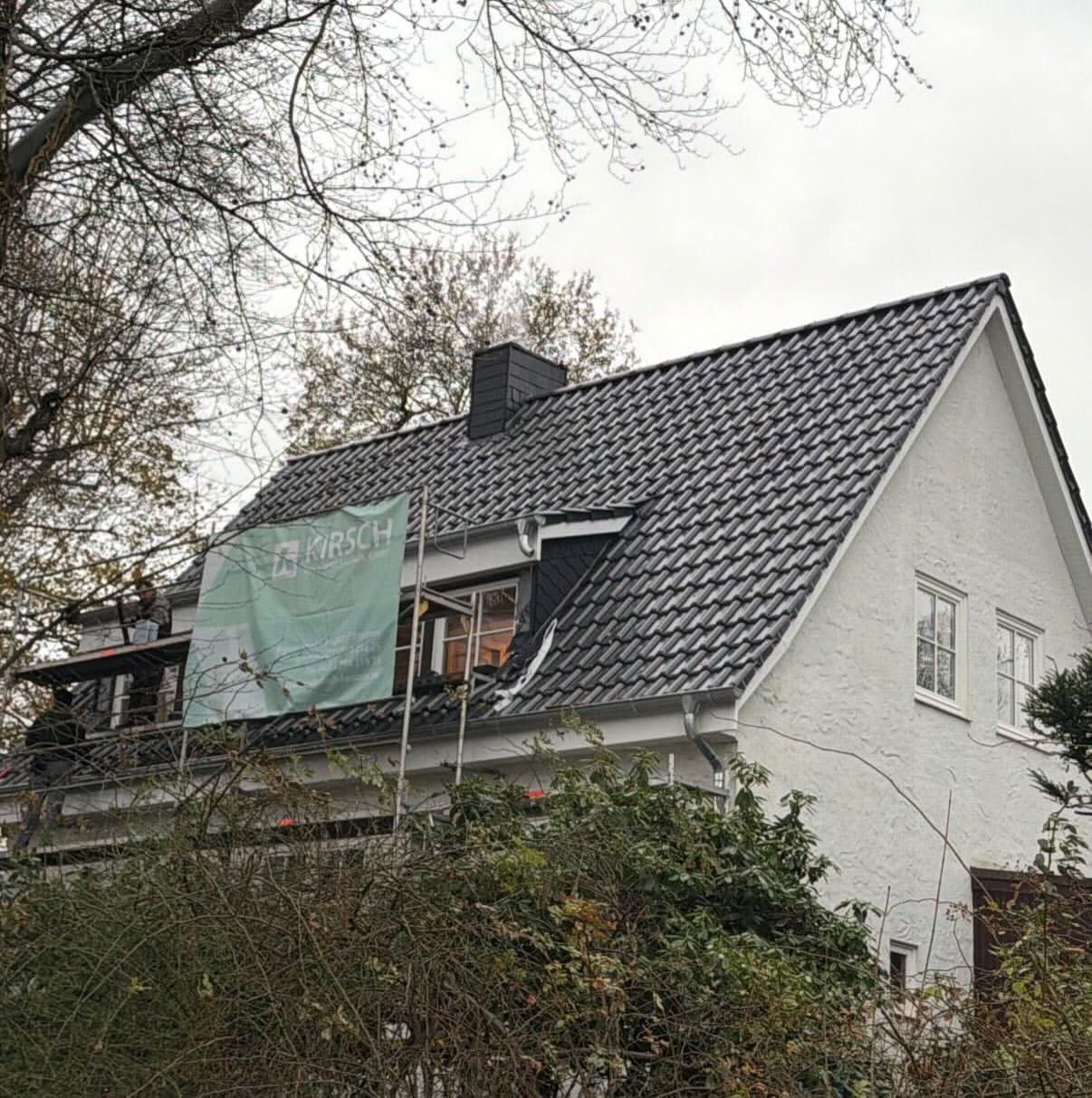 Steildach-Sanierung mit Kirsch-Bauschild auf dem Gerüst