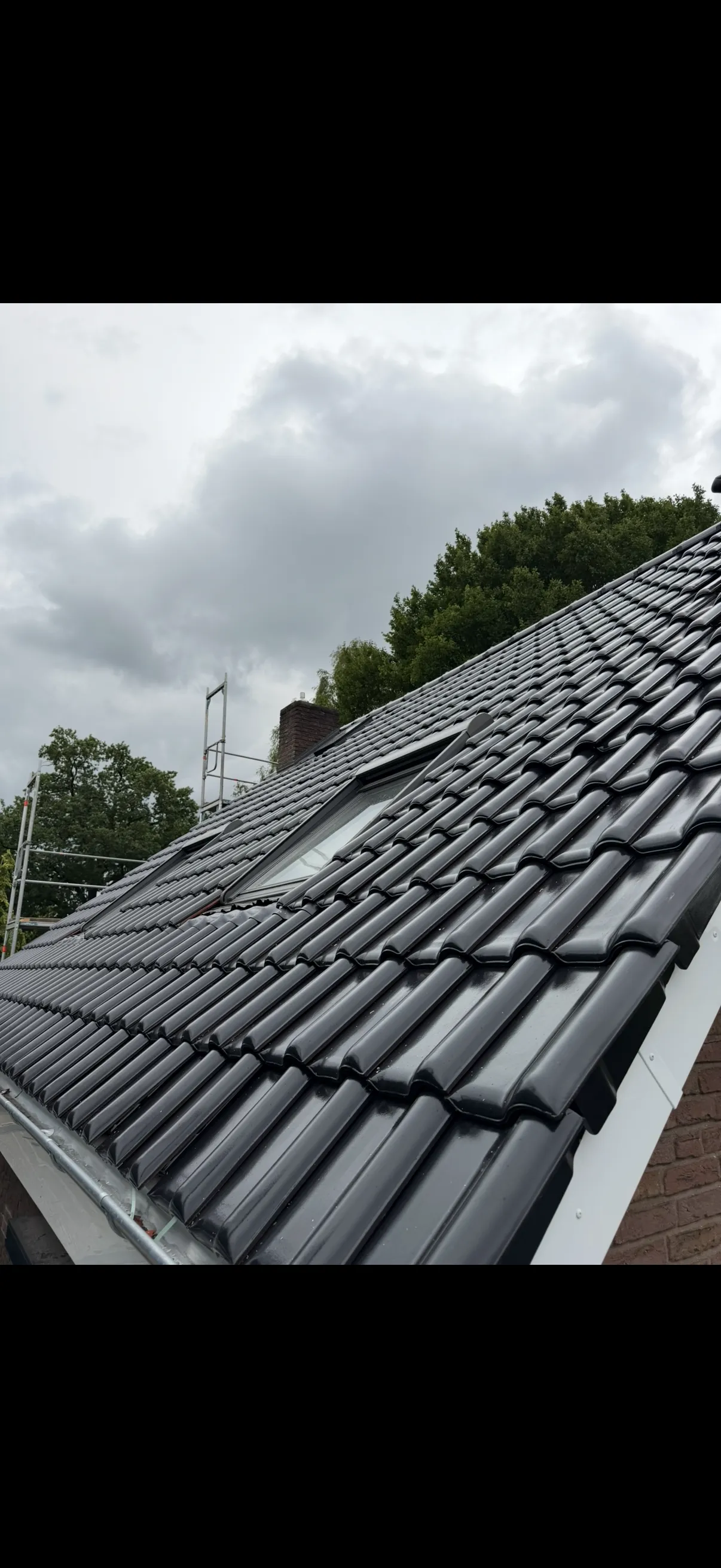 Steildach mit neuen Anthrazit-Ziegeln nach der Sanierung